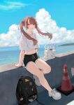  1girl backpack bag blue_sky blush brown_hair cloud crop_top daluto_(hitomi555) day dolphin_shorts full_body highres horizon light_smile long_hair looking_at_viewer navel ocean original outdoors parted_lips pink_eyes pink_hair shirt shoes short_shorts shorts sitting sky sneakers solo traffic_cone twintails wind 