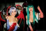  2girl breasts capcom chains cleavage cosplay demon demon_girl green_eyes green_hair lilith_aensland looking_at_viewer monster monster_girl morrigan_aensland pink_hair red_eyes siblings sisters succubus vampire_(game) wings 