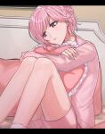  1girl aoki_shizumi bare_legs blush commentary hair_bun hair_ornament hairclip heart heart-shaped_pillow highres hugging_object indoors letterboxed long_sleeves on_bed parted_lips pillow pillow_hug pink_eyes pink_hair pink_shirt pink_shorts shirt shorts sitting solo 
