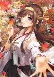  ahoge autumn_leaves bare_shoulders blurry blurry_background blurry_foreground blush breasts brown_hair commentary day depth_of_field detached_sleeves double_bun eyebrows_visible_through_hair hairband headgear highres holding holding_leaf japanese_clothes kantai_collection kongou_(kantai_collection) konkito leaf long_hair looking_at_viewer nontraditional_miko open_mouth outdoors reaching_out remodel_(kantai_collection) skirt smile solo 