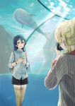  2girls aquarium ayase_eli bangs blonde_hair blue_hair blush camera commentary_request eyebrows_visible_through_hair fish_tank flower hair_between_eyes highres holding holding_camera holding_flower long_hair long_sleeves looking_at_another love_live! love_live!_school_idol_festival love_live!_school_idol_project multiple_girls open_mouth shorts smile solo_focus sonoda_umi standing suito taking_picture thighhighs water yellow_eyes 