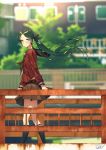  1girl artist_name black_legwear blew_andwhite blurry blurry_background blush brown_serafuku building day green_eyes green_hair hair_ribbon highres kantai_collection kneehighs long_hair long_neck long_sleeves looking_at_viewer mikuma_(kantai_collection) outdoors railing red_ribbon ribbon school_uniform skirt smile solo standing twintails very_long_hair 