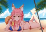  1girl absurdres animal_ear_fluff animal_ears ass beach_umbrella bikini blue_bikini blue_sky breasts butt_crack cleavage collarbone commentary commentary_request crossed_legs fate/grand_order fate_(series) fox_ears fox_girl fox_tail highres large_breasts looking_at_viewer lying ocean on_stomach palm_leaf pink_hair side-tie_bikini sky solo starfish swimsuit tail tamamo_(fate)_(all) tamamo_no_mae_(swimsuit_lancer)_(fate) tming umbrella yellow_eyes 