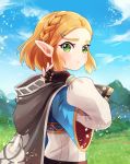  1girl :t amy30535 bangs black_gloves blonde_hair blue_shirt blush braid cape commentary_request day gloves green_eyes hair_ornament hairclip highres holding hood hooded_cape long_sleeves mountain outdoors parted_bangs pointy_ears princess_zelda shirt short_hair solo the_legend_of_zelda upper_body 