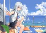 1girl :o bangs bare_legs barefoot black_sailor_collar black_skirt blue_eyes blue_sky blurry blurry_foreground blush cloud commentary_request day depth_of_field eyebrows_visible_through_hair hair_between_eyes hair_flaps hibiki_(kantai_collection) horizon kantai_collection knee_up leaves_in_wind long_hair looking_at_viewer looking_to_the_side miko_fly neckerchief ocean outdoors outstretched_arm parted_lips pleated_skirt railing red_neckwear sailor_collar school_uniform serafuku shirt short_hair short_sleeves signature silver_hair sitting skirt sky solo v very_long_hair water white_shirt 