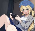  1girl blonde_hair blue_skirt blush controller dokibird_(vtuber) fang feet_out_of_frame game_controller green_eyes grey_jacket holding holding_controller holding_game_controller indie_virtual_youtuber indoors jacket kaniluvv long_hair long_sleeves open_clothes open_jacket shirt signature sitting skin_fang skirt solo twintails virtual_youtuber white_shirt 