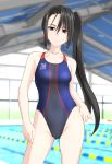  1girl absurdly_long_hair absurdres ass_visible_through_thighs black_hair black_swimsuit blurry breasts brown_eyes commentary_request competition_swimsuit contrapposto depth_of_field highleg highleg_swimsuit highres indoors kantai_collection long_hair looking_at_viewer multicolored multicolored_clothes multicolored_swimsuit nachi_(kantai_collection) one-piece_swimsuit pool side_ponytail small_breasts solo swimsuit takafumi very_long_hair 