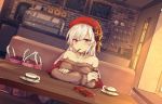  1girl aran_sweater azur_lane belfast_(azur_lane) belfast_(shopping_with_the_head_maid)_(azur_lane) beret blush breasts brown_sweater choker cleavage collarbone dutch_angle earrings food hat hoop_earrings indoors jewelry large_breasts long_hair looking_at_viewer mouth_hold off-shoulder_sweater off_shoulder pocky shinopoko silver_hair sitting smile solo sweater 