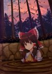  1girl ascot bangs bare_shoulders bare_tree blush bow brown_eyes brown_hair clenched_teeth cloud commentary eyebrows_visible_through_hair falling_leaves frilled_bow frilled_shirt_collar frills hair_bow hair_tubes hakurei_reimu highres kazenokaze leaf outdoors parted_lips partially_submerged red_bow ribbon_trim scared short_hair_with_long_locks sidelocks solo sweat teeth touhou tree twilight upper_body yellow_neckwear 