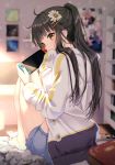  1girl absurdres ahoge barefoot black_hair blue_shorts blurry blurry_background book brown_eyes depth_of_field flower from_behind hair_flower hair_ornament hairclip highres holding jacket knees_up long_hair long_sleeves looking_at_viewer looking_back nintendo_switch original picture_frame ponytail rosuuri scan short_shorts shorts sidelocks sitting solo thighs white_jacket 