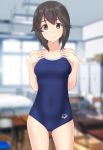  1girl absurdres alternate_costume arena_(company) black_hair blue_swimsuit blurry classroom competition_school_swimsuit contrapposto cowboy_shot depth_of_field hands_on_own_chest hayasui_(kantai_collection) highres indoors kantai_collection logo looking_at_viewer school_swimsuit short_hair silver_eyes solo standing swimsuit takafumi 