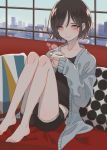  1boy barefoot black_hair blue_jacket blush city coffee coffee_mug collarbone couch cup cushion day highres holding holding_cup indoors jacket kirudai knees knees_up legs lips looking_at_viewer mug on_couch open_clothes open_jacket original otoko_no_ko pillow red_eyes shorts skyline sleeves_past_wrists smile solo steam tsurime window 