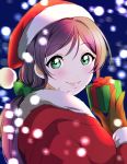  1girl blue_background blurry blush bokeh box christmas commentary_request depth_of_field fur-trimmed_sleeves fur_trim gift gift_box gloves green_eyes green_scrunchie hat highres holding holding_gift kate_iwana lipstick long_hair long_sleeves looking_at_viewer looking_back love_live! love_live!_sunshine!! makeup santa_costume santa_hat scrunchie smile solo toujou_nozomi twintails upper_body 