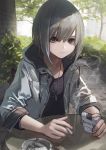  1girl absurdres ashtray bangs cigarette cigarette_box ear_piercing expressionless flat_chest grey_eyes grey_hair hair_between_eyes hashimoto_kokai highres holding holding_cigarette hood hoodie looking_at_viewer original outdoors piercing short_hair smoke solo table tree 