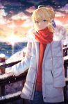  1girl ahoge artoria_pendragon_(all) bangs blonde_hair blue_eyes blue_ribbon braid braided_bun breath cloud coat commentary cowboy_shot elker evening eyebrows_visible_through_hair fate/stay_night fate_(series) green_eyes hair_between_eyes hair_ribbon highres lighthouse long_sleeves looking_at_viewer multicolored multicolored_eyes ocean outdoors railing red_scarf ribbon saber scarf short_hair sidelocks sleeves_past_wrists smile snow snowing standing sunset white_coat winter winter_clothes 