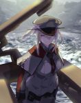  1girl blonde_hair breasts capelet celtic_knot cloud graf_zeppelin_(kantai_collection) grey_eyes grey_sky hair_between_eyes hat iron_cross jacket kantai_collection large_breasts machinery military military_hat military_uniform necktie ocean peaked_cap sidelocks solo tsurime twintails uniform upper_body waves yamaioni_(sasakama) 