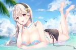  1girl absurdres bare_legs bare_shoulders barefoot beach bead_bracelet bead_necklace beads bikini black_bikini blue_sky bracelet breasts chin_rest cleavage cloud cloudy_sky collarbone commentary corrin_(fire_emblem) corrin_(fire_emblem)_(female) day droplet fire_emblem fire_emblem_fates full_body hair_between_eyes hairband highres jewelry large_breasts long_hair looking_at_viewer lying necklace ocean on_stomach open_mouth oramikainu outdoors palm_tree partially_submerged pointy_ears red_eyes shell shell_bikini silver_hair sky smile soles solo splashing starfish swimsuit tree 