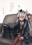  1girl amatsukaze_(kantai_collection) blanket brown_dress commentary_request couch dress feet_out_of_frame garter_straps hair_tubes hat highres kantai_collection kuuru_(kuuru-n) long_hair looking_at_viewer mini_hat plaid red_legwear sailor_dress short_dress silver_hair simple_background sitting smokestack_hair_ornament solo striped striped_legwear thighhighs translation_request two_side_up white_background windsock 