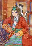  1girl animal_on_head beads blue_eyes braid brown_hair carpet cat cushion hair_beads hair_ornament highres holding long_hair luoyang_liyufu_guagua on_floor on_head original parted_lips pellet_drum red_robe robe sash sitting solo tassel tibetan_clothes 