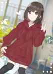  1girl 7_calpis_7 bangs black_hair black_legwear blurry blurry_background blush brown_eyes closed_mouth commentary_request day depth_of_field dutch_angle eyebrows_visible_through_hair hand_up highres hood hoodie hoodie_dress indoors long_sleeves original red_hoodie sleeves_past_wrists smile solo thighhighs v 