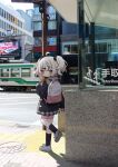  1girl ahoge backpack bag black_jacket black_skirt black_socks blush brown_eyes building closed_mouth commentary_request day grey_footwear grey_hair hair_ornament hairclip highres holding_strap jacket long_sleeves looking_at_viewer looking_to_the_side nakkar original outdoors photo_background plaid plaid_skirt pleated_skirt puffy_long_sleeves puffy_sleeves road shoes skirt sleeves_past_wrists socks solo standing standing_on_one_leg street twintails twitter_username watermark window 