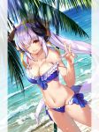  1girl bangs bare_shoulders beach bikini blue_bikini blue_sky blush bow breasts cleavage collarbone dragon_girl dragon_horns fate/grand_order fate_(series) frilled_bikini frills hair_ornament highres horns kiyohime_(fate/grand_order) kiyohime_(swimsuit_lancer)_(fate) large_breasts long_hair looking_at_viewer multiple_horns naginata navel ocean one_eye_closed open_mouth palm_tree polearm ponytail red_eyes renka_(renkas) sidelocks silver_hair sky smile strap_pull swimsuit thighs tree weapon wet yellow_bow 