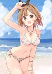  1girl :d armpits atelier_(series) atelier_ryza beach bikini black_hairband blue_sky breasts brown_eyes brown_hair cloud commentary_request eyebrows_visible_through_hair hair_ornament hairband hairclip hand_up highres jewelry looking_at_viewer medium_breasts minidraco navel necklace o-ring o-ring_bottom ocean open_mouth outdoors reisalin_stout sand short_hair sky smile solo star_(symbol) star_necklace swimsuit water white_bikini 
