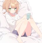  1girl barefoot blue_shorts blush breasts cup green_eyes hair_ornament highres holding holding_cup indie_virtual_youtuber light_brown_hair mug no_pupils pillow pom_pom_(clothes) pom_pom_hair_ornament shigure_ui_(vtuber) shiramacu shirt shorts sitting solo steam virtual_youtuber white_shirt 