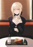  1girl artoria_pendragon_(all) bangs black_bow black_dress blonde_hair bow braid braided_bun breasts cleavage closed_mouth collarbone dress drinking_straw eyebrows_visible_through_hair fate/stay_night fate_(series) food gothic_lolita hair_bow hamburger harukaze_(rori_0826) highres holding holding_food indoors lolita_fashion long_sleeves saber_alter shiny shiny_hair short_hair_with_long_locks sidelocks sitting small_breasts solo yellow_eyes 