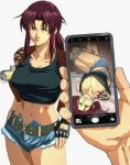  1boy 1girl argent_moon arm_tattoo black_lagoon bound breasts cowboy_shot fingerless_gloves fur-trimmed_shorts fur_trim gag gagged glaring gloves highres holding holding_phone looking_at_viewer phone revy_(black_lagoon) short_shorts shorts simple_background tape tape_bondage tattoo white_background yellow_eyes 