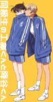  2boys amuro_tooru bangs blonde_hair blue_eyes blue_jacket blue_shorts brown_hair closed_mouth commentary_request covered_mouth full_body gym_shirt gym_shorts gym_uniform hair_between_eyes head_on_another&#039;s_shoulder jacket k_(gear_labo) kudou_shin&#039;ichi leaning_forward long_sleeves looking_at_another male_focus meitantei_conan multiple_boys shirt shoes short_hair shorts simple_background sneakers socks standing track_jacket translation_request white_footwear white_legwear yellow_background 