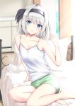  1girl alternate_costume arm_support arm_up bangs bare_arms bare_legs barefoot bed bedroom blue_eyes blurry blurry_background breasts camisole collarbone day english_commentary expressionless eyebrows_visible_through_hair green_shorts hair_ribbon head_tilt highres holding holding_hair indoors konpaku_youmu light_rays looking_at_viewer on_bed parted_lips pillow ribbon short_hair shorts silver_hair sitting small_breasts solo spaghetti_strap sunbeam sunlight tim86231 touhou white_camisole wooden_floor yokozuwari 