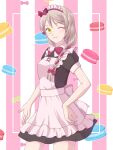 1girl alternate_costume apron asagao_l blonde_hair bow closed_mouth fire_emblem fire_emblem_engage food framme_(fire_emblem) frilled_apron frills hair_bow hand_on_own_hip highres light_smile macaron maid maid_headdress multicolored_hair one_eye_closed pink_bow pink_hair solo split-color_hair striped_background yellow_eyes 
