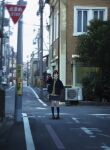  1girl black_hair black_legwear blurry building cityscape commentary day depth_of_field english_commentary hand_in_pocket kneehighs loafers original outdoors road road_sign sakeharasu school_uniform shoes short_hair sign solo street tree uniform utility_pole 