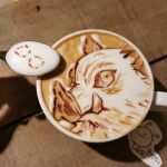  1boy boar_mask coffee coffee_mug cup food food_art hashibira_inosuke highres kimetsu_no_yaiba latte_art looking_at_viewer mug photo_(medium) portrait runapocket shadow solo spoon unconventional_media 