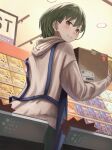  1girl apron blue_apron blush box brown_eyes carrying casual cd_case display_case from_below green_hair highres hood hoodie idolmaster idolmaster_shiny_colors long_sleeves looking_back nanakusa_nichika record_store shop short_hair solo working yanoyoru 