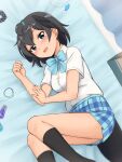  1girl :d absurdres alternate_costume bangs black_eyes black_hair black_legwear blue_bow blue_neckwear blue_skirt blush bow bowtie commentary feet_out_of_frame greater_lophorina_(kemono_friends) head_wings highres indoors jewelry kemono_friends kneehighs looking_at_viewer lying on_bed on_side open_mouth pendant pendant_removed plaid plaid_skirt pleated_skirt school_uniform scrunchie scrunchie_removed shiraha_maru shirt short_hair short_sleeves skirt smile solo tail white_shirt 