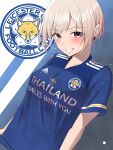  1girl adidas bangs blonde_hair blue_background blue_shirt blush breasts brown_eyes clothes_writing collarbone commentary_request earrings eyebrows_visible_through_hair grin highres idolmaster idolmaster_cinderella_girls jewelry k-chitsu leicester_city_fc logo looking_at_viewer medium_breasts parted_bangs shiomi_shuuko shirt short_hair short_sleeves sidelocks smile soccer_uniform solo sportswear standing teeth trait_connection two-tone_background upper_body white_background 