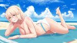  1girl :d absurdres ahoge barefoot beach bikini bikini_bottom blonde_hair blue_bow blue_sky bow bracelet breasts cleavage cloud collarbone day eyebrows_visible_through_hair fate/grand_order fate_(series) green_eyes hair_between_eyes hair_bow hand_in_hair highres jewelry looking_at_viewer lying medium_breasts medium_hair ocean okita_souji_(fate)_(all) okita_souji_(swimsuit_assassin)_(fate) on_stomach open_mouth outdoors shiny shiny_hair shiny_skin sky smile soles solo swimsuit tacochu the_pose topless white_bikini 