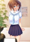  1girl arms_at_sides bangs blue_eyes blue_skirt blurry blurry_foreground blush breasts brown_hair commentary_request cowboy_shot hair_between_eyes highres ichi_makoto indoors large_breasts original pleated_skirt school_uniform short_sleeves skirt solo 