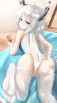  1girl absurdres adjusting_clothes adjusting_swimsuit animal_ears ass azur_lane bare_shoulders beach beach_towel blue_eyes cien_(shikanokuni) crazy_straw cup drinking_glass drinking_straw feet from_behind highres kawakaze_(azur_lane) long_hair looking_at_viewer one-piece_swimsuit solo swimsuit thighhighs towel white_hair white_legwear white_swimsuit 