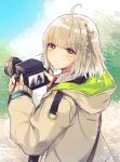  1girl ahoge amiya_(arknights) arknights beige_jacket blonde_hair camera commentary doctor_(arknights) dslr eyebrows_visible_through_hair facing_away hair_ornament highres holding holding_camera hood hood_down infection_monitor_(arknights) looking_at_viewer looking_back nanatsuka outdoors scene_(arknights) short_hair side_ponytail signature snowflake_hair_ornament solo upper_body wristband yellow_eyes 