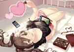  1girl bare_legs bed_sheet black_shirt blush bow brown_eyes brown_hair cellphone chocolate collarbone dutch_angle eyebrows_visible_through_hair food frilled_shirt frills hair_bow hair_ornament heart heart_hair_ornament highres holding holding_chocolate holding_food indoors long_hair looking_at_viewer lying nintendo_switch on_back on_bed original phone phone_screen pillow pink_shorts red_ribbon ribbon shirt shorts smartphone smile solo sunlight toujou_mina twintails 