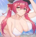  1girl bangs bare_shoulders beach bikini black_headwear blue_sky blush breasts cleavage collarbone eyebrows_visible_through_hair fang hair_ribbon hand_on_headwear hat heterochromia highres hololive houshou_marine large_breasts leaning_forward long_hair looking_at_viewer ocean pirate red_eyes red_hair red_ribbon ribbon shaggy_susu sky smile solo sunlight swimsuit twintails virtual_youtuber water wet white_bikini yellow_eyes 