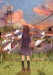  1girl black_legwear black_shirt black_skirt brown_hair cable car cloud cloudy_sky commentary_request fence from_behind grass ground_vehicle house kneehighs lamppost long_hair motor_vehicle original outdoors radio_tower scenery shirt skirt sky sunset tamagogayu1998 town 