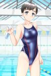  1girl absurdres black_hair blue_eyes blue_swimsuit breasts clothes_writing commentary_request competition_swimsuit cowboy_shot highres indoors lane_line looking_at_viewer one-piece_swimsuit original pool short_hair small_breasts solo standing string_of_flags swim_cap_removed swimsuit takafumi water white_headwear 