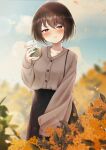  1girl absurdres black_skirt blush breasts brown_hair brown_sweater cloud collarbone cup disposable_cup eyebrows_visible_through_hair flower highres holding holding_cup kazanock long_skirt long_sleeves medium_breasts orange_flower original osmanthus outdoors pout red_eyes short_hair skirt sky sleeves_past_wrists solo sweater 