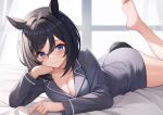  1girl animal_ears barefoot black_hair blue_eyes blush breasts cleavage closed_mouth collarbone eishin_flash_(umamusume) foot_up highres horse_ears horse_girl horse_tail large_breasts long_sleeves looking_at_viewer lying on_stomach pajamas short_hair smile solo tail umamusume vococo window 