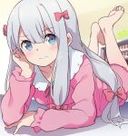  1girl arm_support bangs barefoot blue_eyes blush closed_mouth eromanga_sensei eyebrows_visible_through_hair hair_ribbon hand_on_own_cheek hand_on_own_face highres izumi_sagiri light_frown long_hair looking_at_viewer lying on_stomach pajamas pink_pajamas pink_ribbon ribbon sidelocks silver_hair solo suwakana the_pose wavy_mouth 