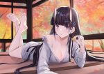  1girl autumn azur_lane bangs barefoot black_hair blunt_bangs breasts cleavage closed_mouth commentary_request crossed_ankles eyebrows_visible_through_hair feet full_body grey_shirt hair_ornament hairclip highres horns lim_(ramu) long_hair long_sleeves looking_at_viewer lying manjuu_(azur_lane) medium_breasts noshiro_(azur_lane) noshiro_(cozy_enclave)_(azur_lane) off_shoulder official_alternate_costume on_stomach oni_horns purple_eyes shirt soles solo the_pose toes very_long_hair 